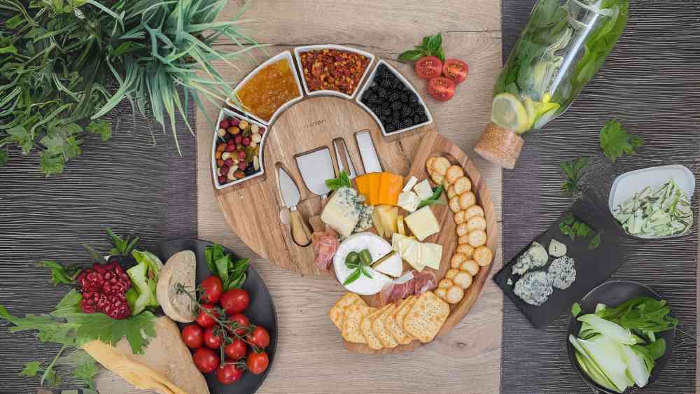 charcuterie board with cheese utensils and bowls