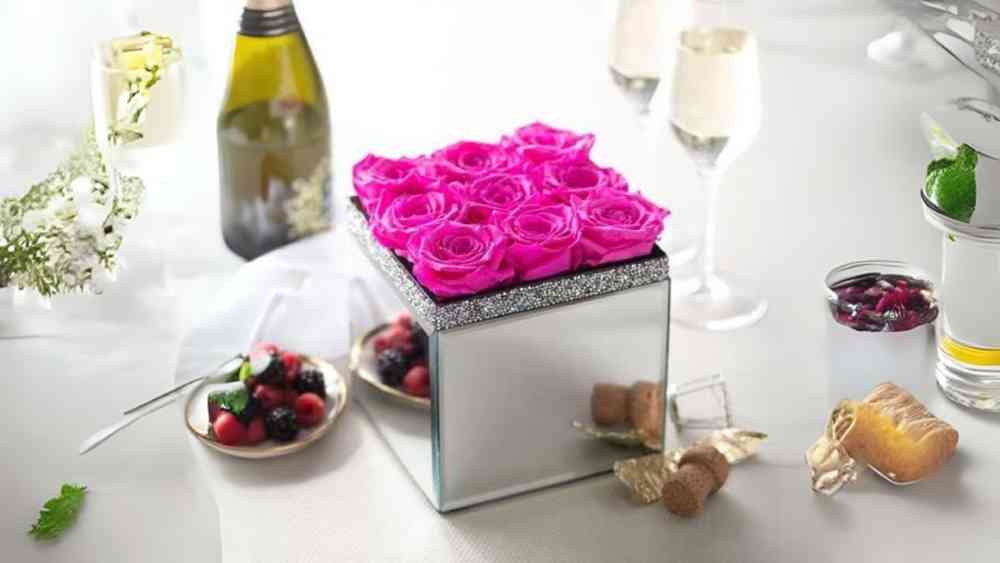 Large mirrored cubic vase of nine preserved roses