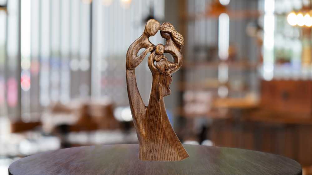 Couple holding a baby wooden statue