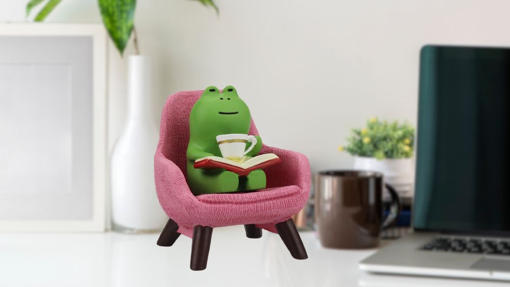 Small frog figurine reading book